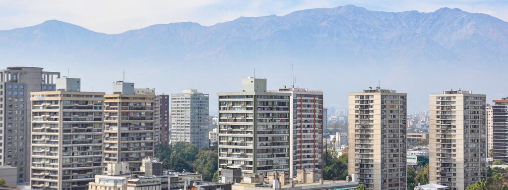 Edificios de departamentos de Santiago con la cordillera de los Andes al fondo